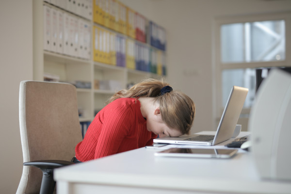 Kopf auf Tisch vor Laptop 600