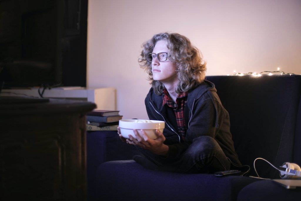 mann-mit-einer-schuessel-popcorn-vor-dem-fernseher-zu-hause